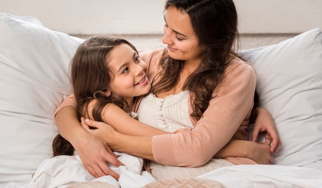 madre-e-hija-abrazandose-cama_23-2148396020