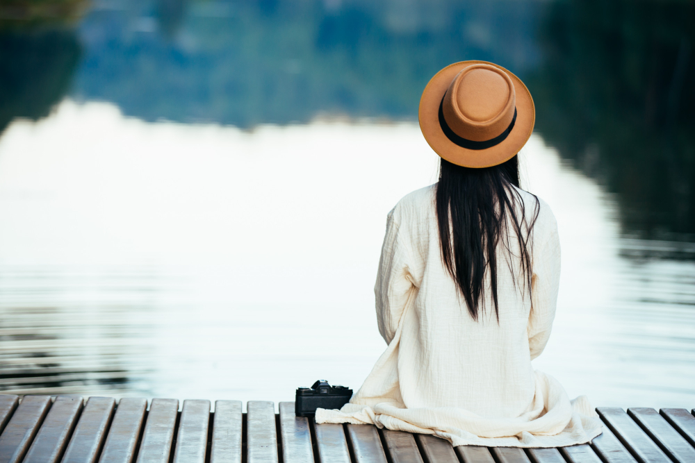 lonely-woman-sitting-on-the-waterfront-raft