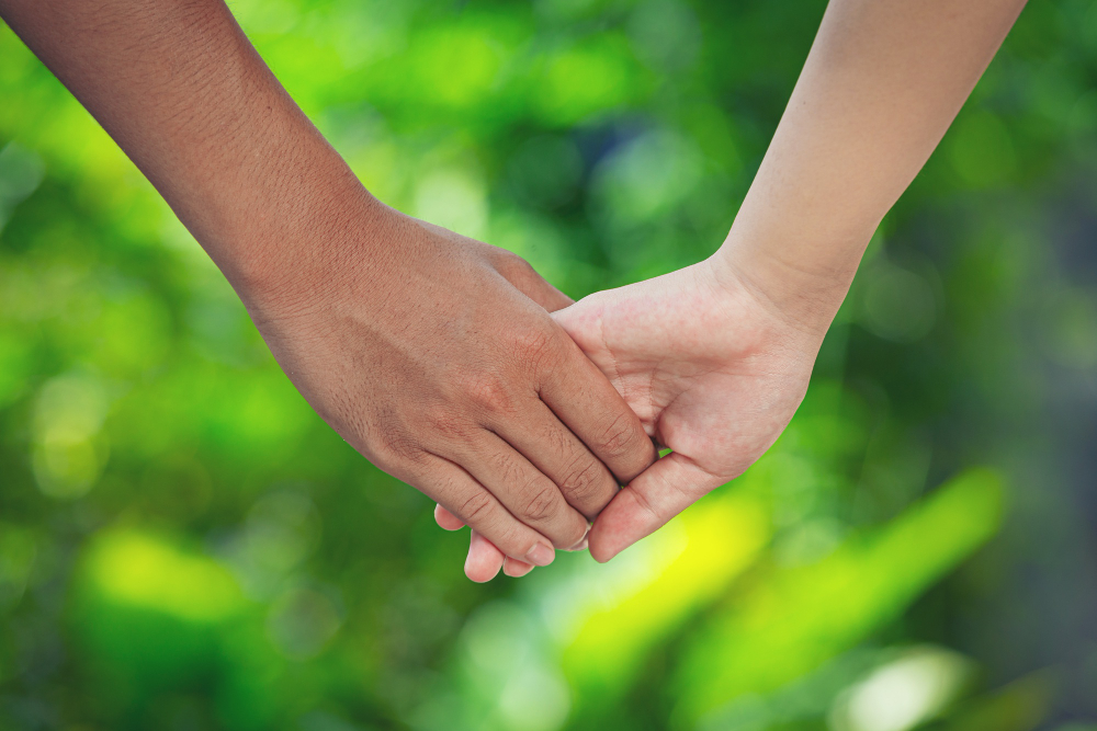 couple-holding-hands-in-green-meadow