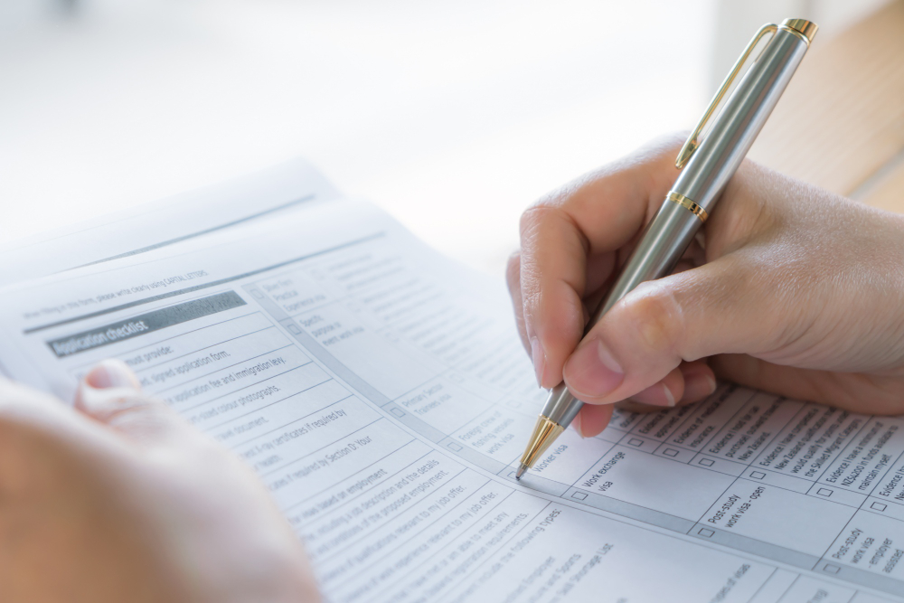 hand-with-pen-over-application-form