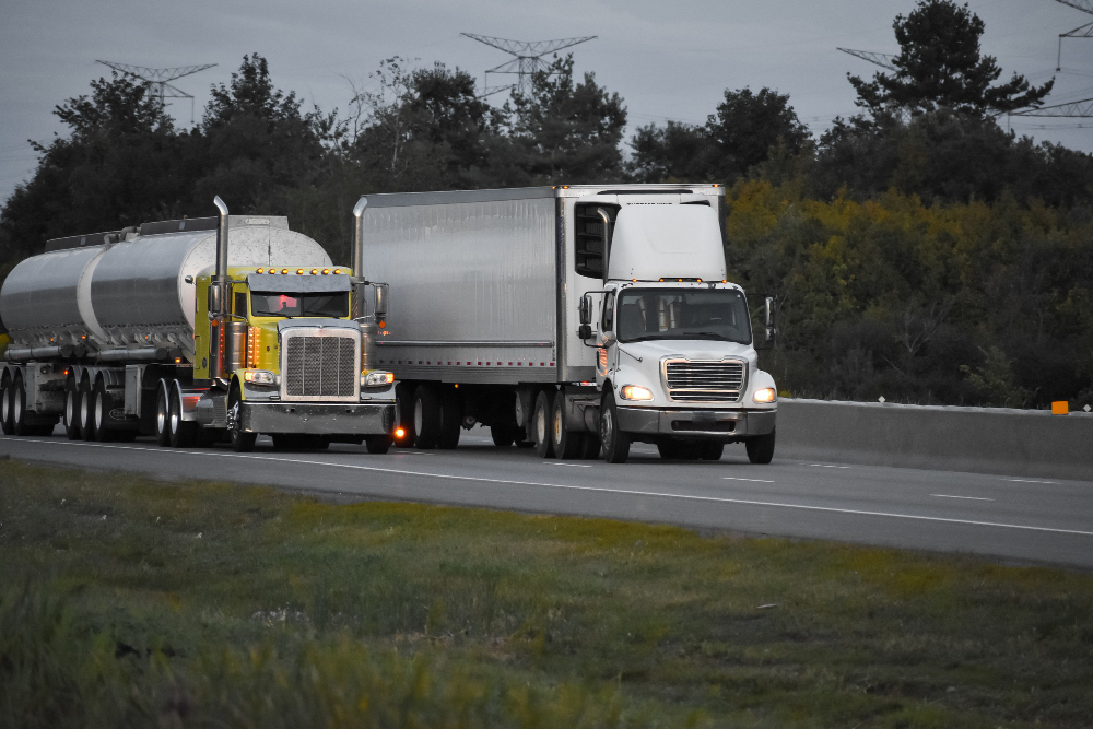 trailer-trucks-driving-on-the-road-surrounded-by-beautiful-green-trees
