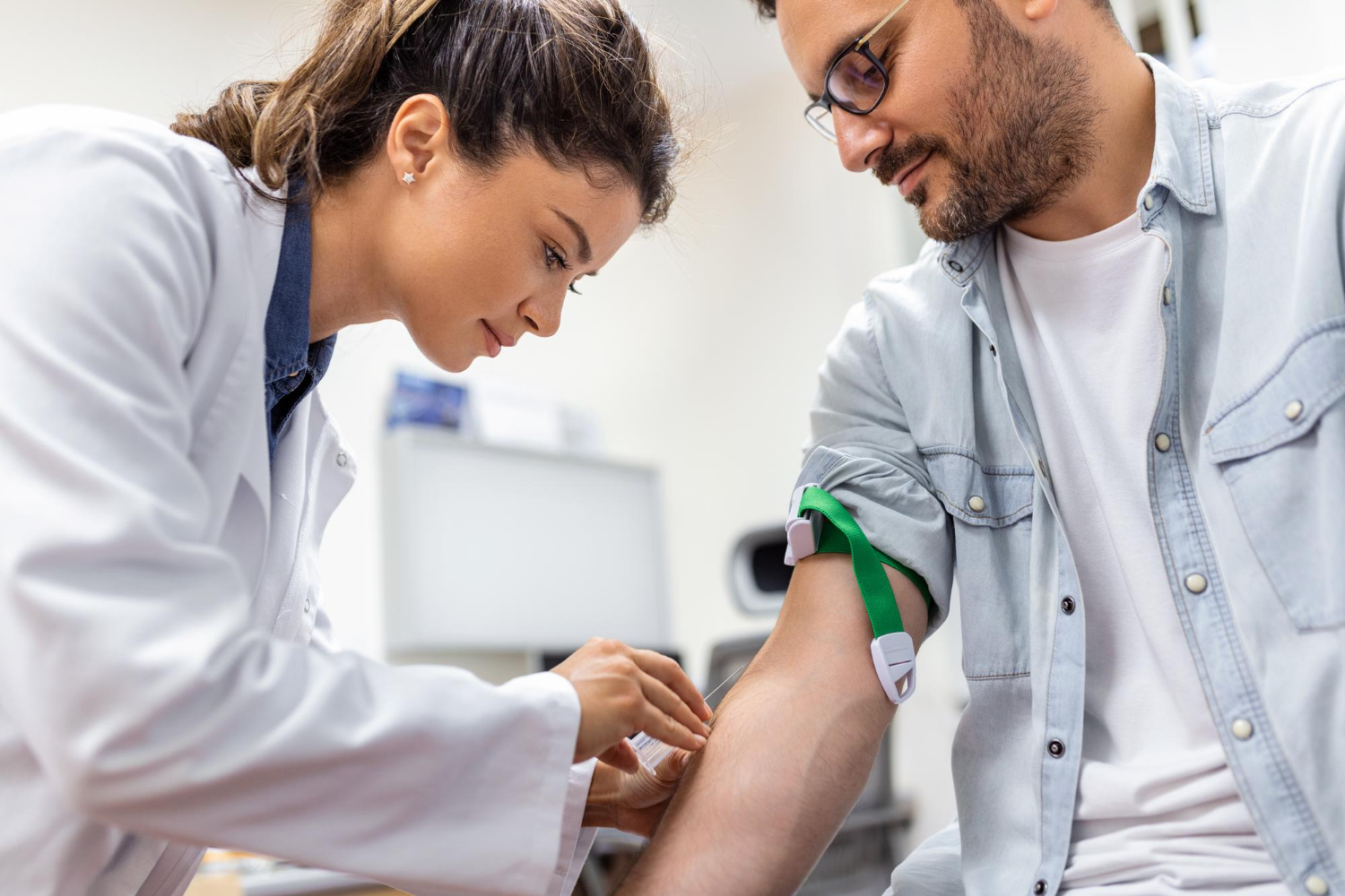 amigavel-flebotomista-do-hospital-coletando-amostra-de-sangue-do-paciente-no-laboratorio-preparacao-para-exame-de-sangue-pelo-uniforme-medico-feminino-na-mesa-na-sala-branca-brilhante