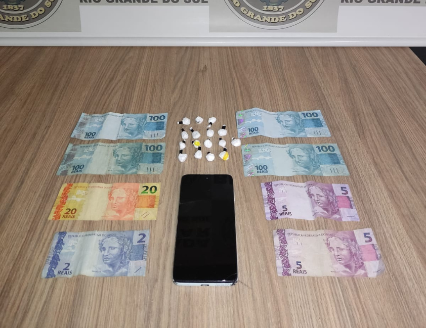 Ação ocorreu durante barreira de trânsito no Centro; drogas, dinheiro e celular foram apreendidos