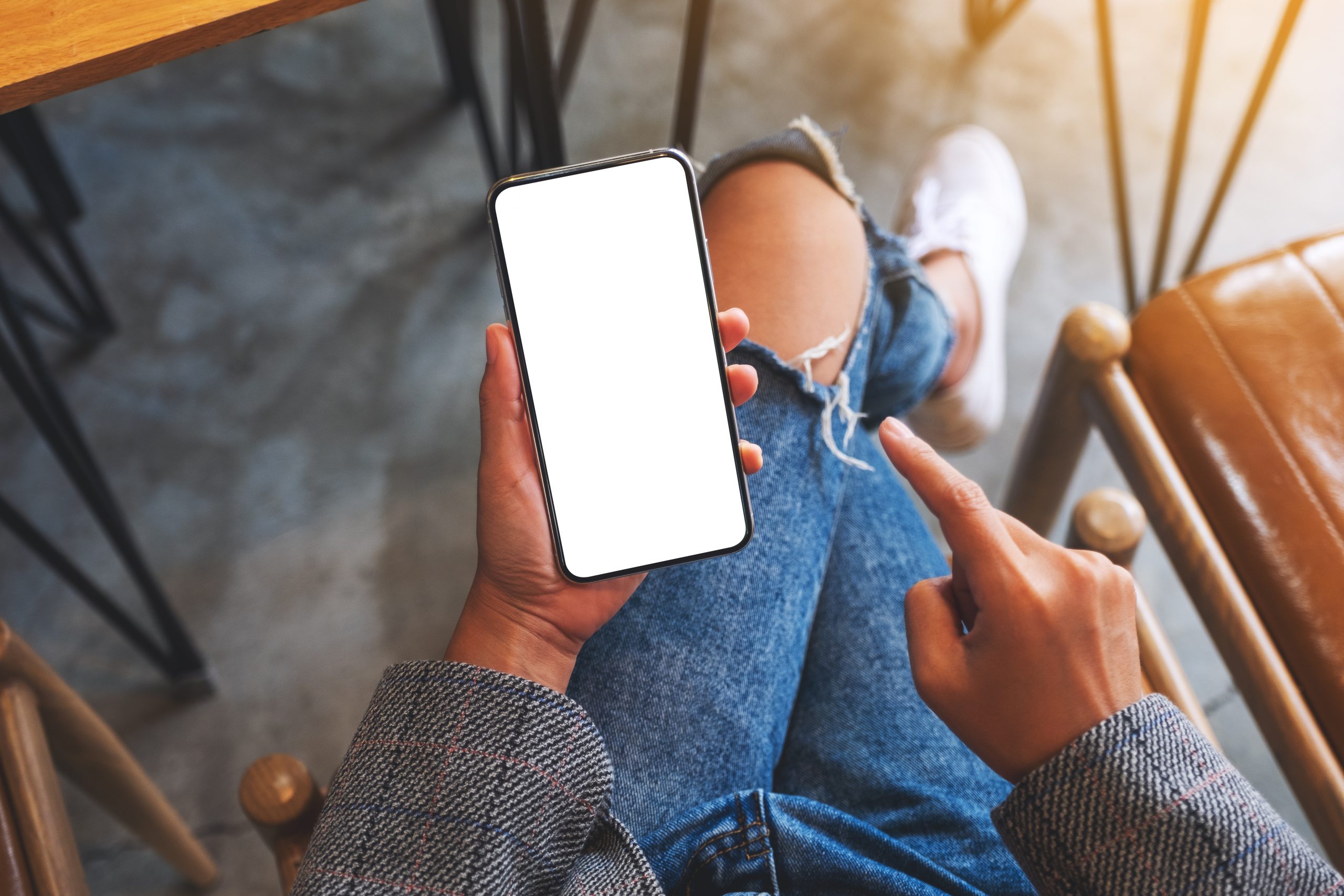 Top view mockup image of a woman holding and pointing finger at