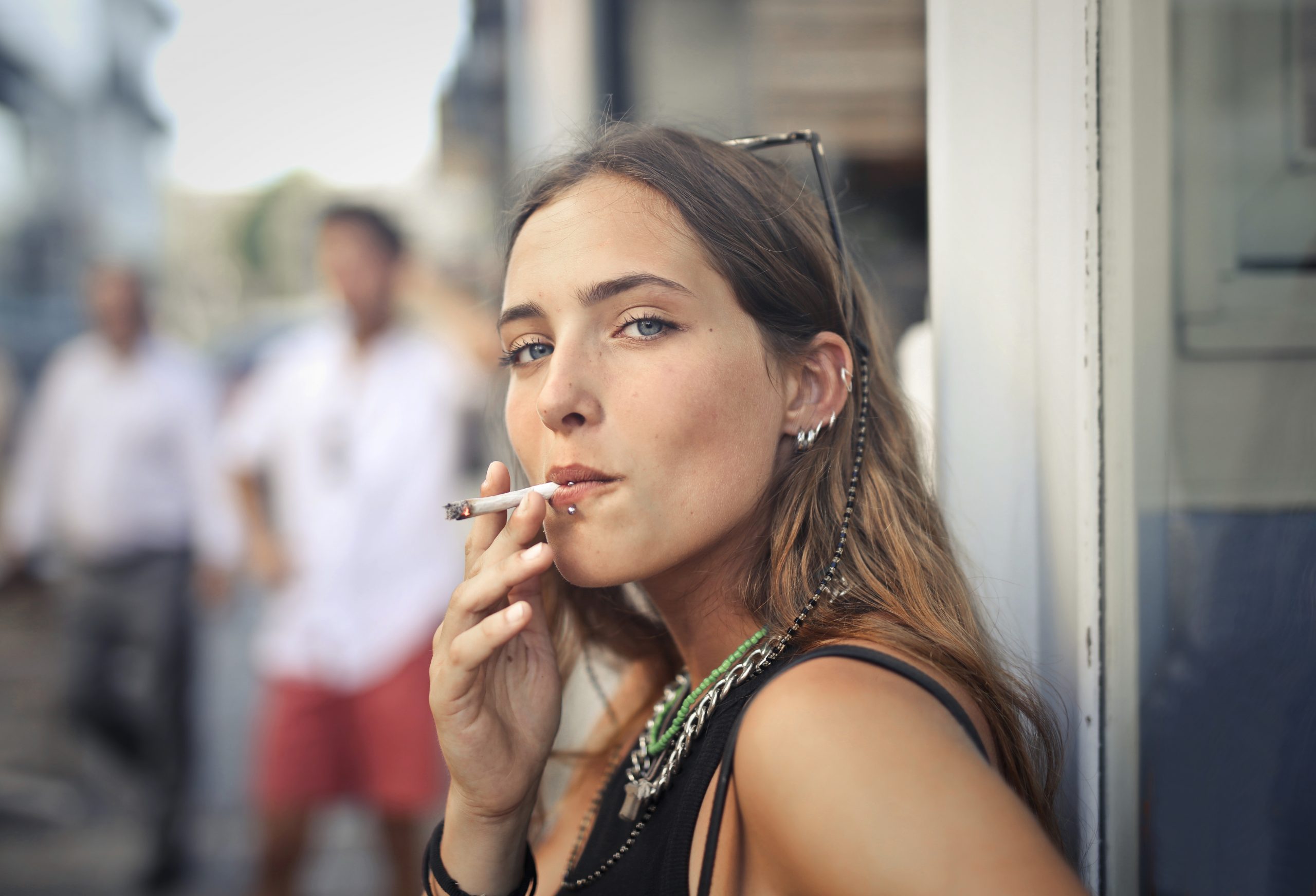A portrait of a young female smoking in the street