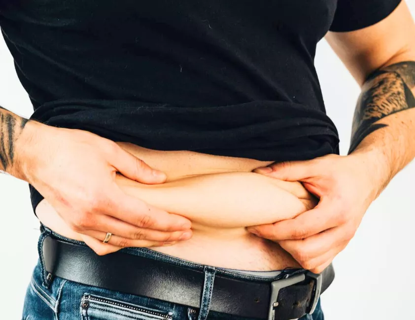 homem de meia-idade segurando a barriga