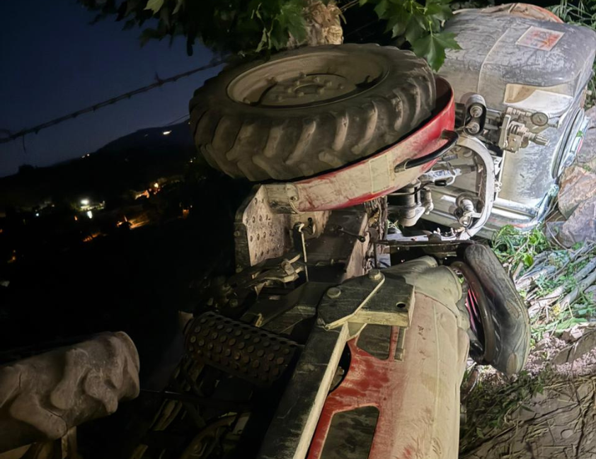 Trator capotado em declive dentro de parreiral na Linha 15 da Graciema, área rural de Bento Gonçalves, durante atendimento noturno do Corpo de Bombeiros