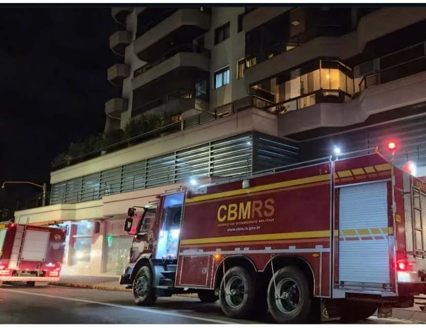 Fogo provocado pelo acúmulo de fuligem foi controlado antes de atingir apartamentos, e moradores precisaram suspender o uso das lareiras. Um princípio de incêndio mobilizou o Corpo de Bombeiros na noite de quarta-feira (29), em um edifício residencial localizado na Rua Ramiro Barcelos, no Centro de Bento Gonçalves. A ocorrência foi registrada por volta das 19h53 e terminou sem feridos ou danos à estrutura do prédio. Ao chegarem ao local, os bombeiros identificaram fumaça saindo do duto da chaminé, nas proximidades do 10º andar. A avaliação apontou que o fogo teve início devido à ignição da fuligem acumulada no interior da tubulação, situação comum quando a limpeza preventiva não é realizada com a frequência necessária. As equipes realizaram o combate às chamas e impediram que o incêndio se espalhasse para apartamentos ou outras áreas da edificação. Após a extinção do fogo, foi feita uma inspeção em todos os pavimentos e no interior da chaminé, sem a identificação de novos focos. Como medida de segurança, os moradores foram orientados a desligar todas as lareiras ligadas ao mesmo duto até que seja realizada a limpeza e manutenção completa da chaminé. O síndico também recebeu orientações para evitar novos incidentes. Segundo os bombeiros, o prédio possui o Alvará de Prevenção e Proteção Contra Incêndio (APPCI) em dia, conforme as normas vigentes.
